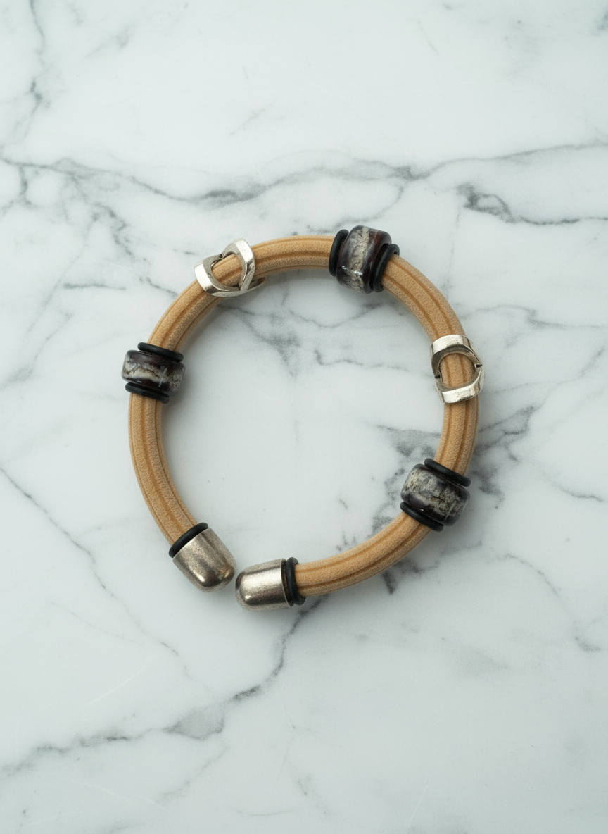 Bracelet with wooden band and metallic accents on a marble background